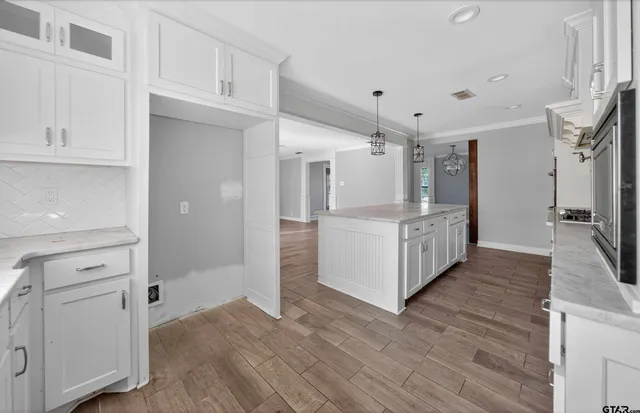 a view of a kitchen with refrigerator and white cabinets