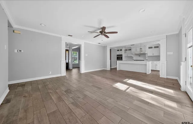 a view of a kitchen with wooden floor and a ceiling fan