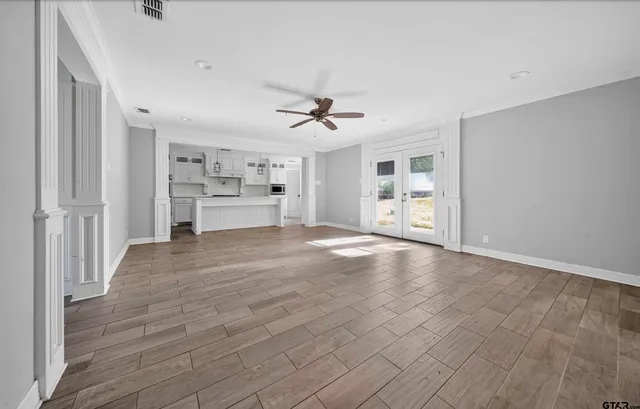 wooden floor in an empty room with a kitchen