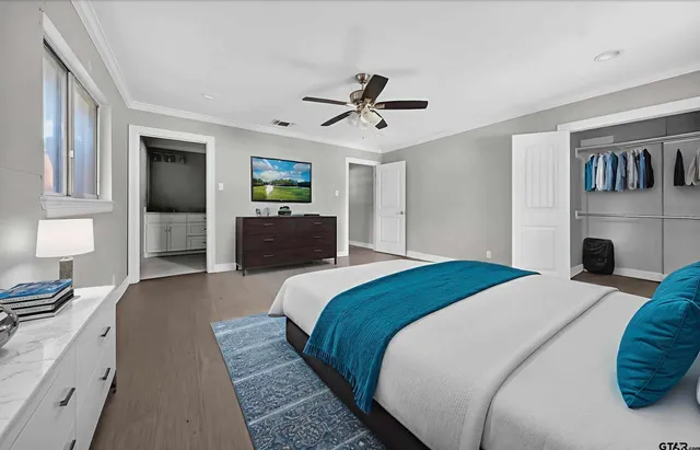 a bedroom with a large bed and a chandelier