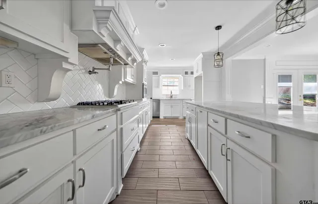 a kitchen with stainless steel appliances granite countertop lots of counter space and wooden floors