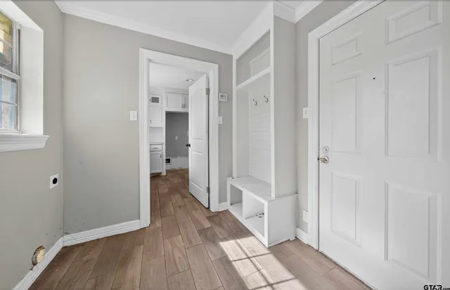 a view of a hallway with wooden floor and closet area