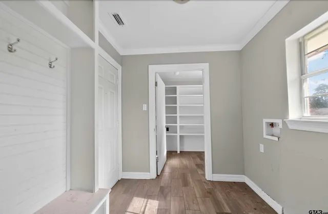 a view of empty room with wooden floor and window