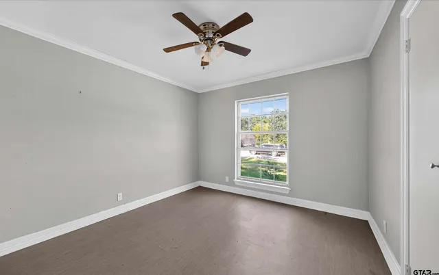 an empty room with a window and a fan