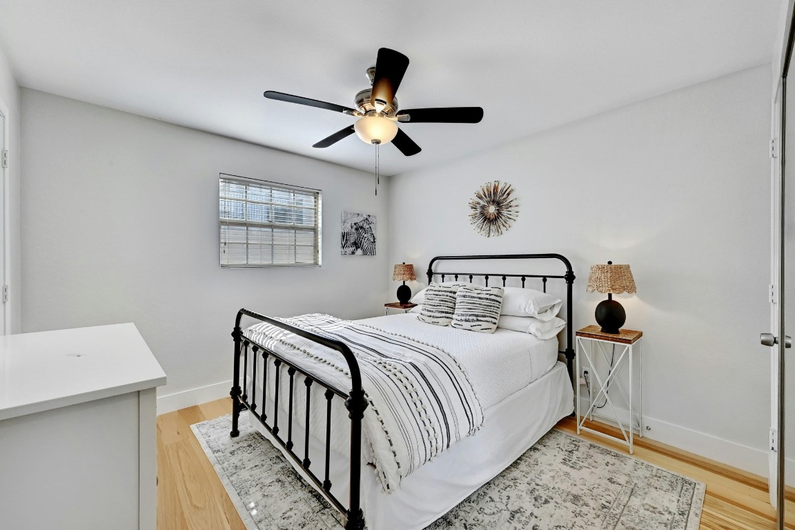 1307 Norwalk Lane, Unit 104 Austin, TX 78703 - Photo 12 of 22 a bedroom with a bed and a chandelier