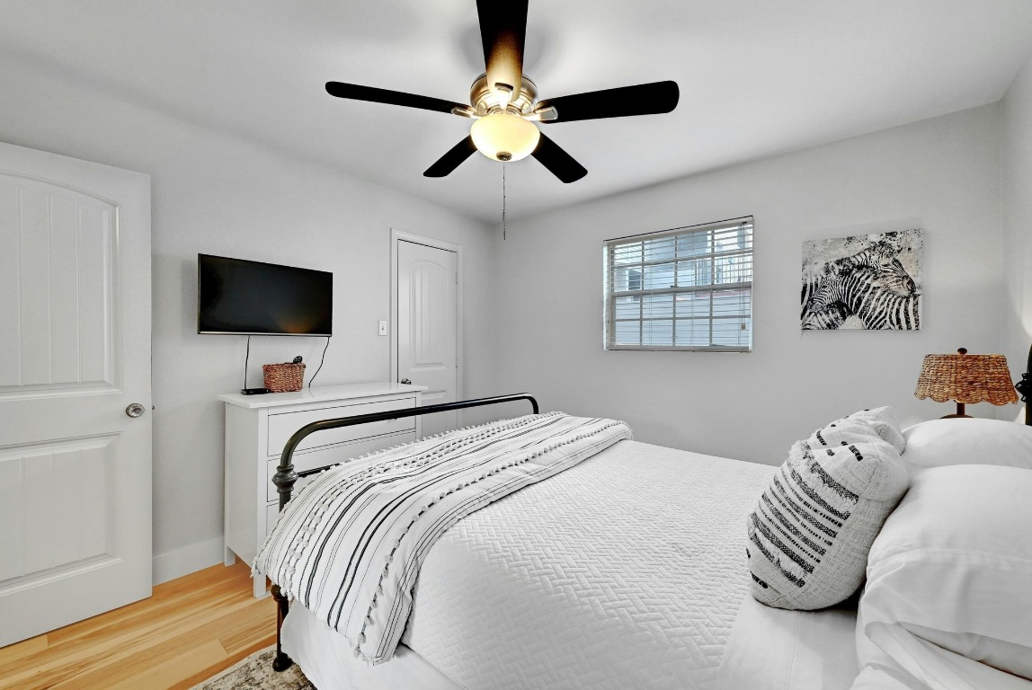 1307 Norwalk Lane, Unit 104 Austin, TX 78703 - Photo 13 of 22 a bedroom with a bed and a flat screen tv