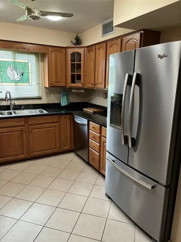 a kitchen with stainless steel appliances granite countertop a refrigerator and a sink