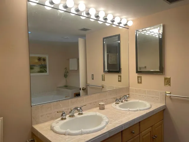 a bathroom with double vanity sinks and a mirror