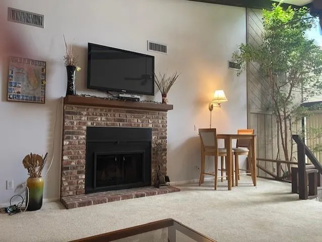 a living room with furniture a fireplace and a flat screen tv