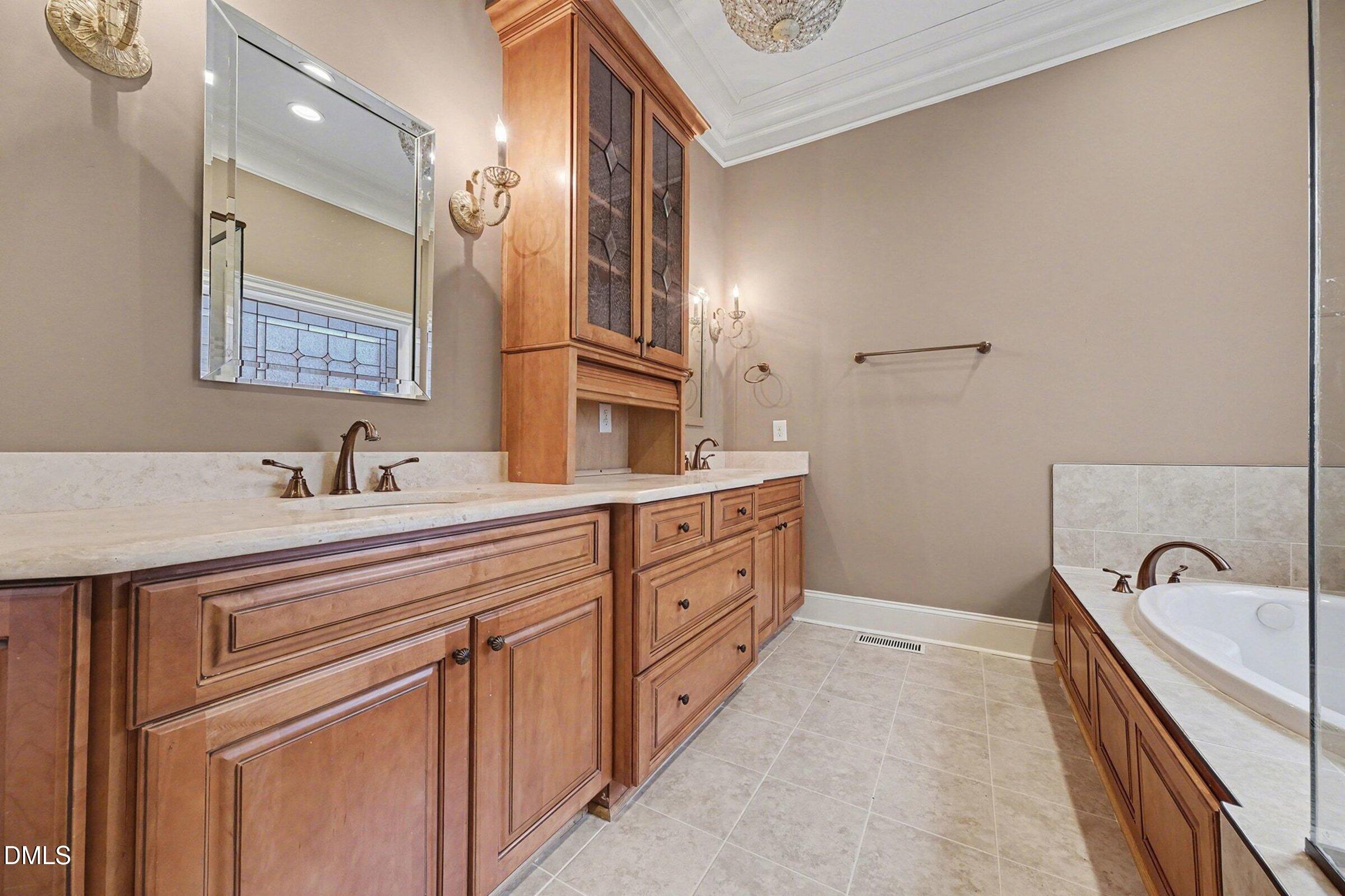 4105 Gardenlake Drive Raleigh, NC 27612 - Photo 18 of 28 a spacious bathroom with a double vanity sink a mirror and a bathtub