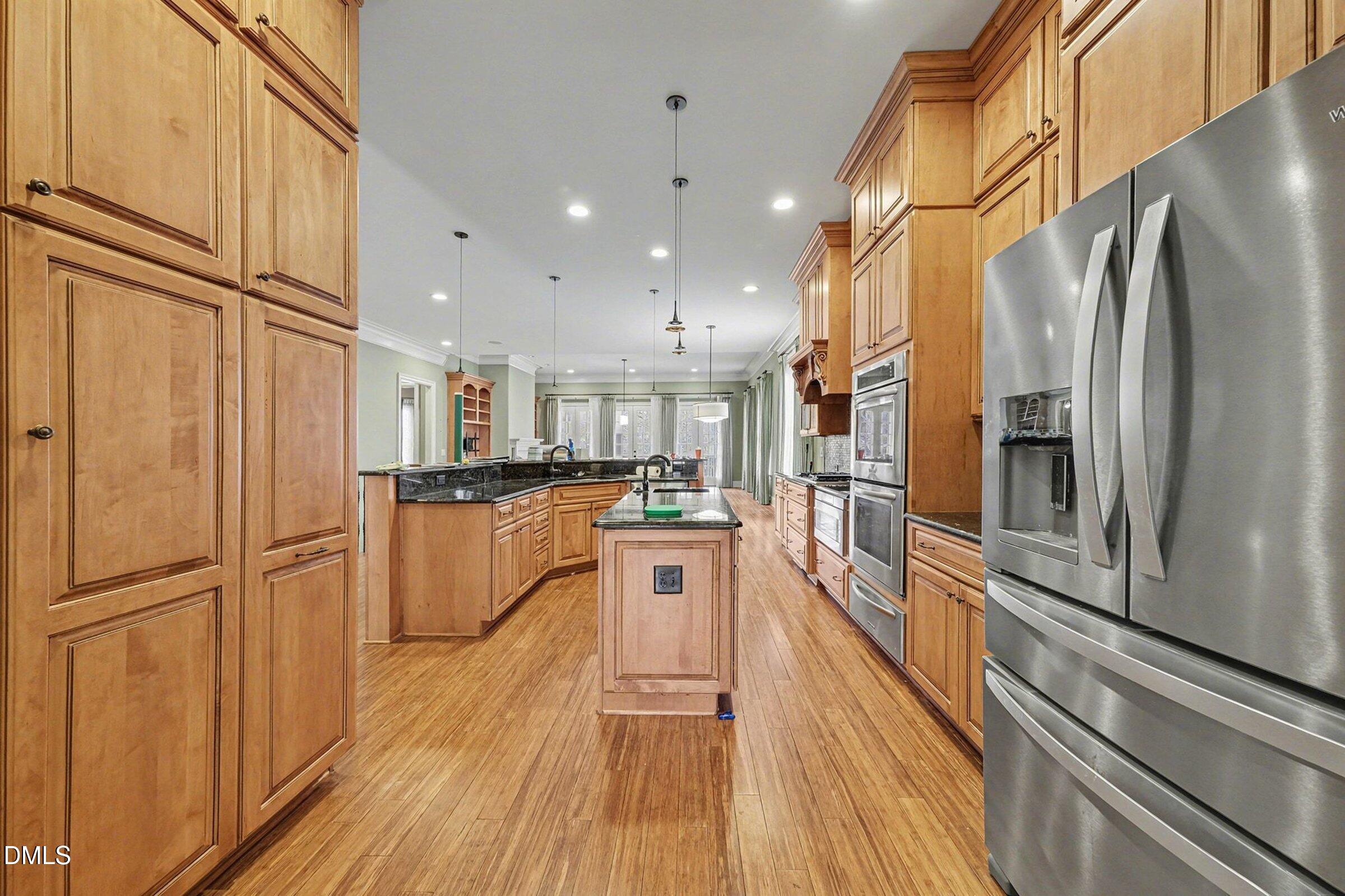 4105 Gardenlake Drive Raleigh, NC 27612 - Photo 7 of 28 a kitchen with stainless steel appliances granite countertop a refrigerator a stove and a wooden floors
