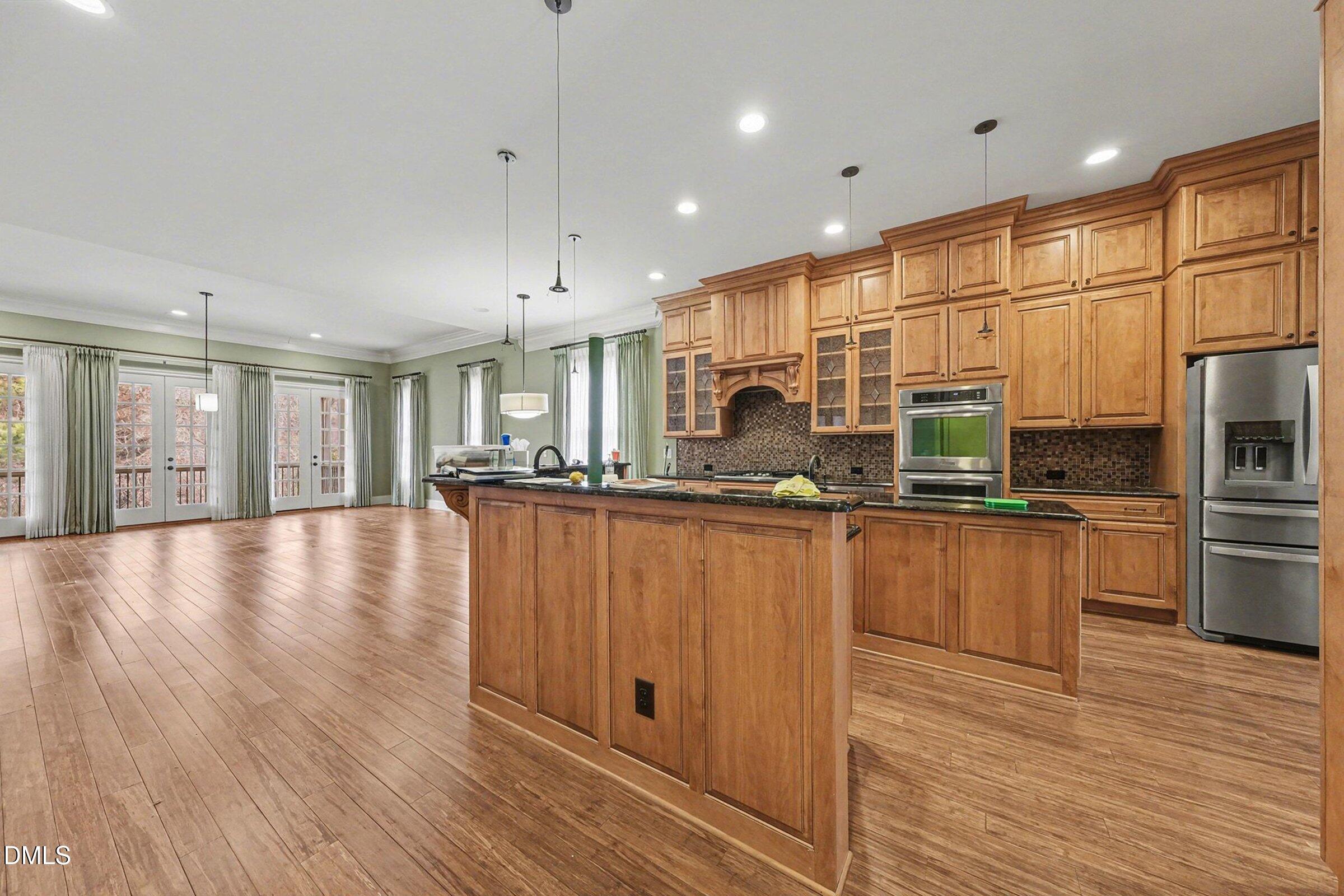 4105 Gardenlake Drive Raleigh, NC 27612 - Photo 8 of 28 a kitchen with stainless steel appliances granite countertop a refrigerator a oven a stove and a wooden floors