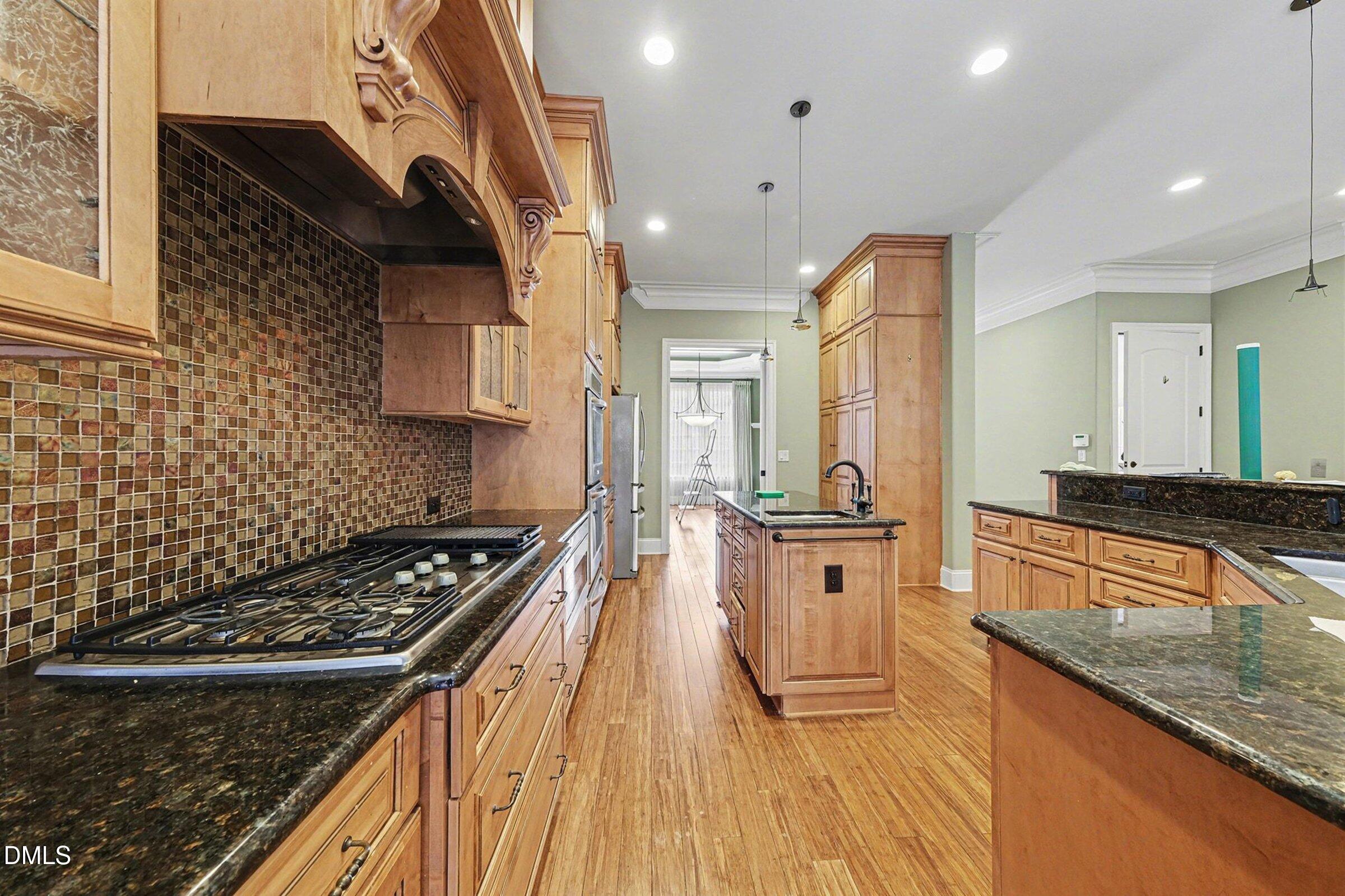 4105 Gardenlake Drive Raleigh, NC 27612 - Photo 9 of 28 a kitchen with stainless steel appliances granite countertop a stove a sink and a refrigerator