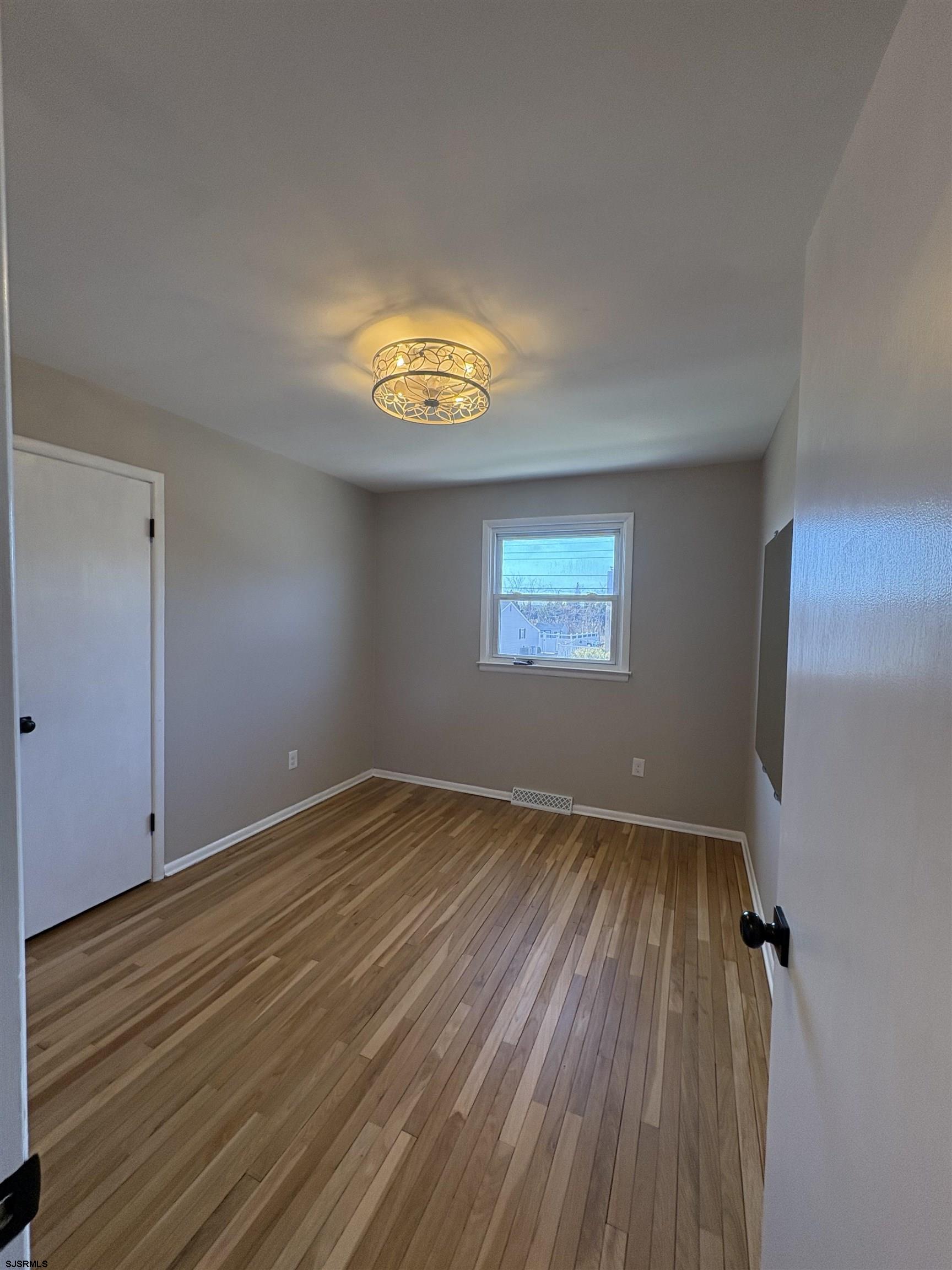 31 Gulph Mill Road Somers Point, NJ 08244 - Photo 13 of 32 wooden floor in an empty room with a window