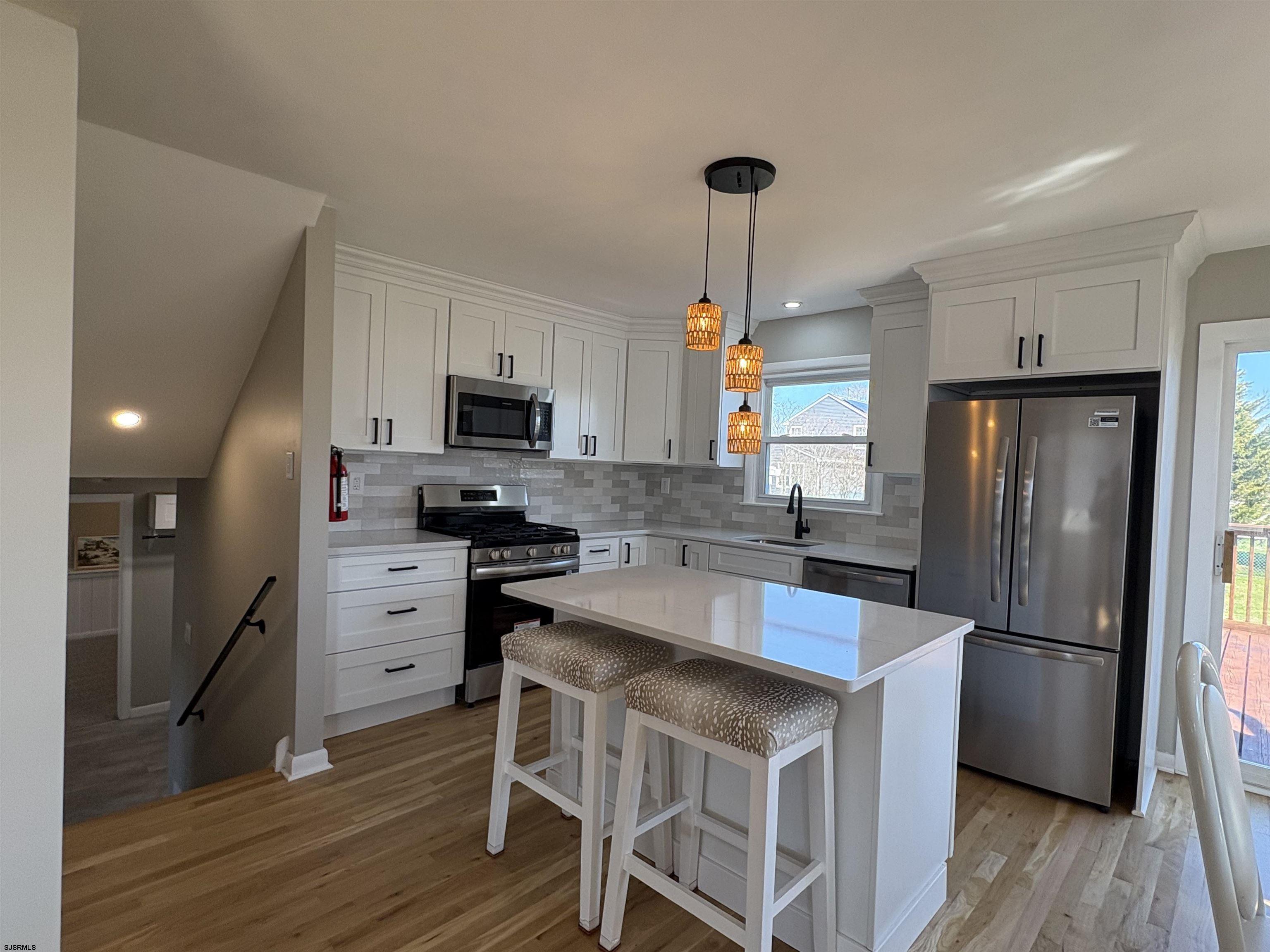 31 Gulph Mill Road Somers Point, NJ 08244 - Photo 2 of 32 a kitchen with granite countertop a refrigerator a stove a sink and a center island