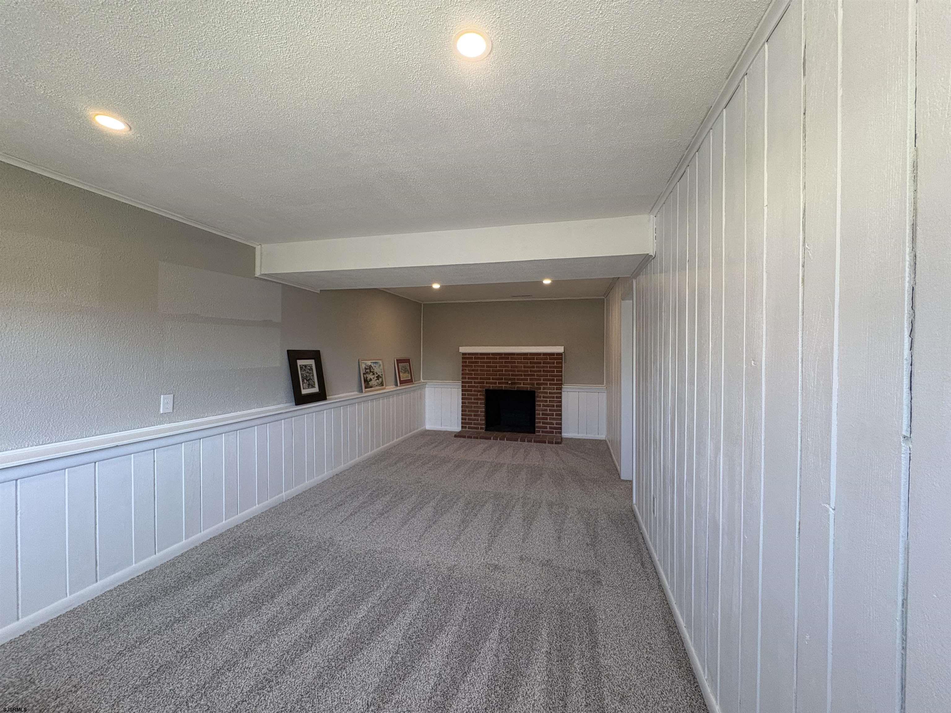 31 Gulph Mill Road Somers Point, NJ 08244 - Photo 22 of 32 a view of empty room with wooden floor and fireplace
