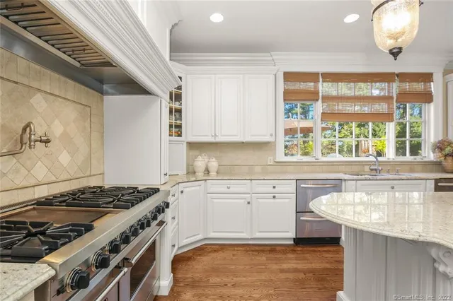 a kitchen with a stove a sink and a window
