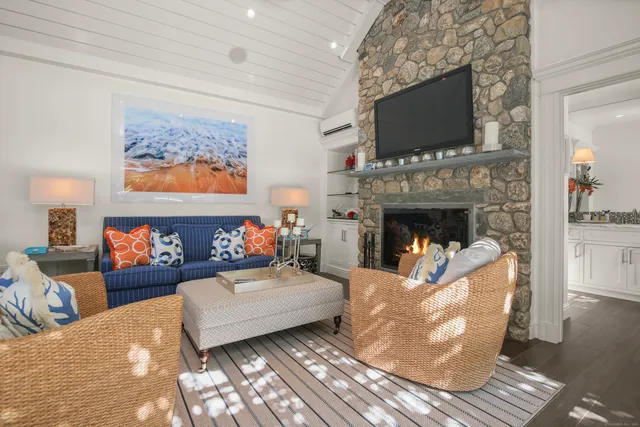 a living room with furniture a flat screen tv and a fireplace