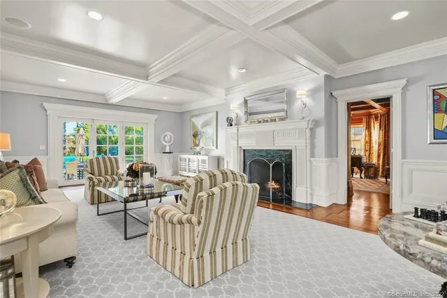 a living room with furniture a fireplace and a floor to ceiling window