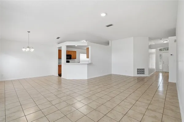 a view of a hallway with wooden floor and a kitchen space