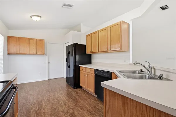 a kitchen with stainless steel appliances granite countertop a refrigerator and a stove top oven