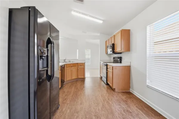 a kitchen with stainless steel appliances granite countertop a sink a stove cabinets and wooden floor