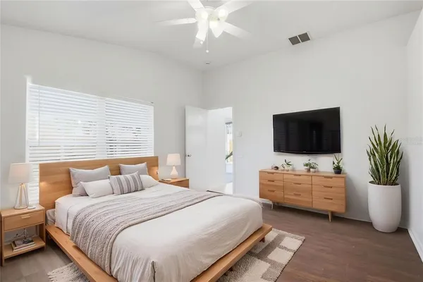 a bedroom with a bed and a flat tv screen on dresser
