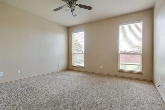 an empty room with a window and a fan