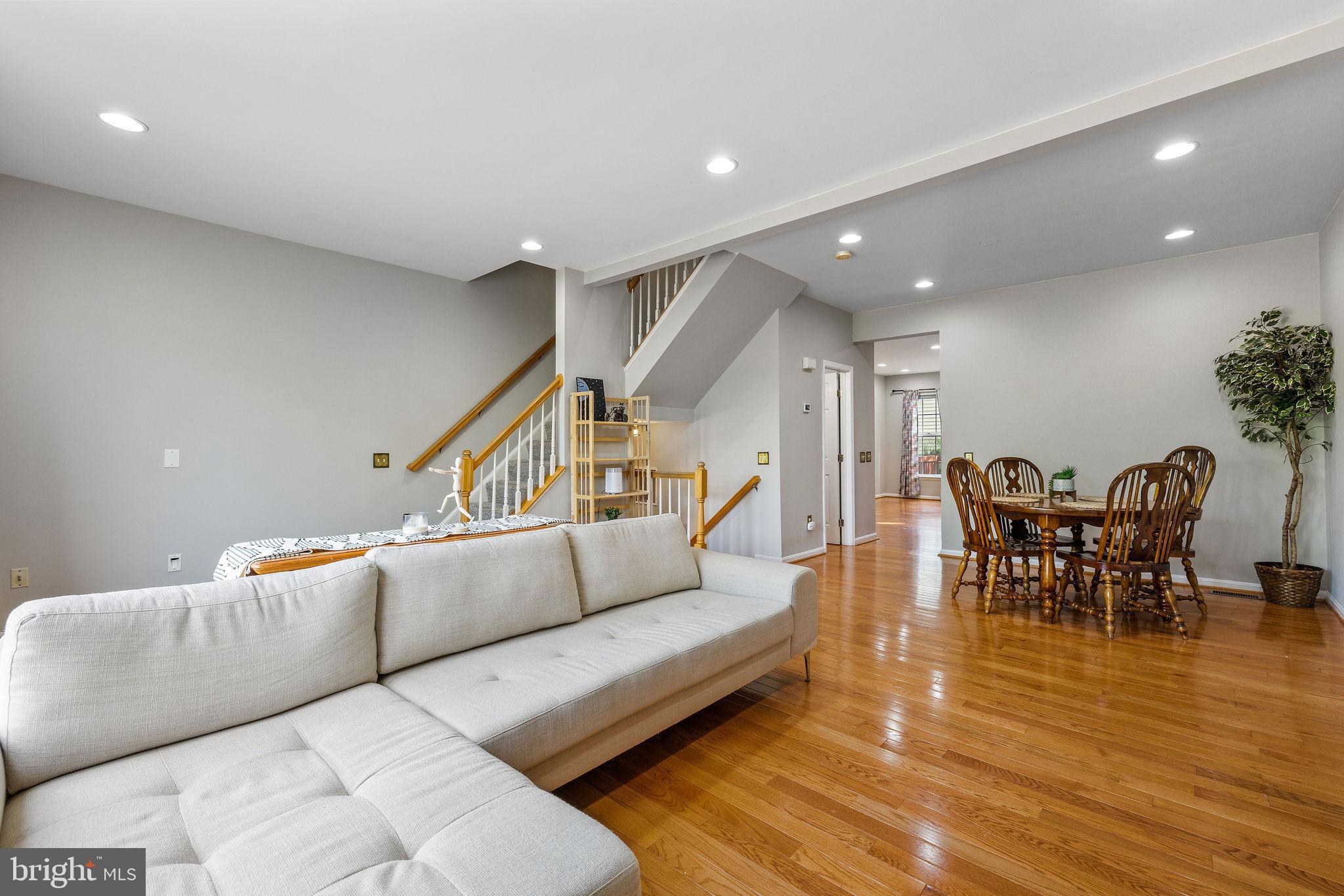 13503 Bannacker Place Herndon, VA 20171 - Photo 12 of 61 a living room with furniture and a dining table with wooden floor