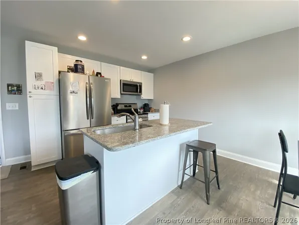 a dining room with wooden floor a chandelier a wooden table and chairs