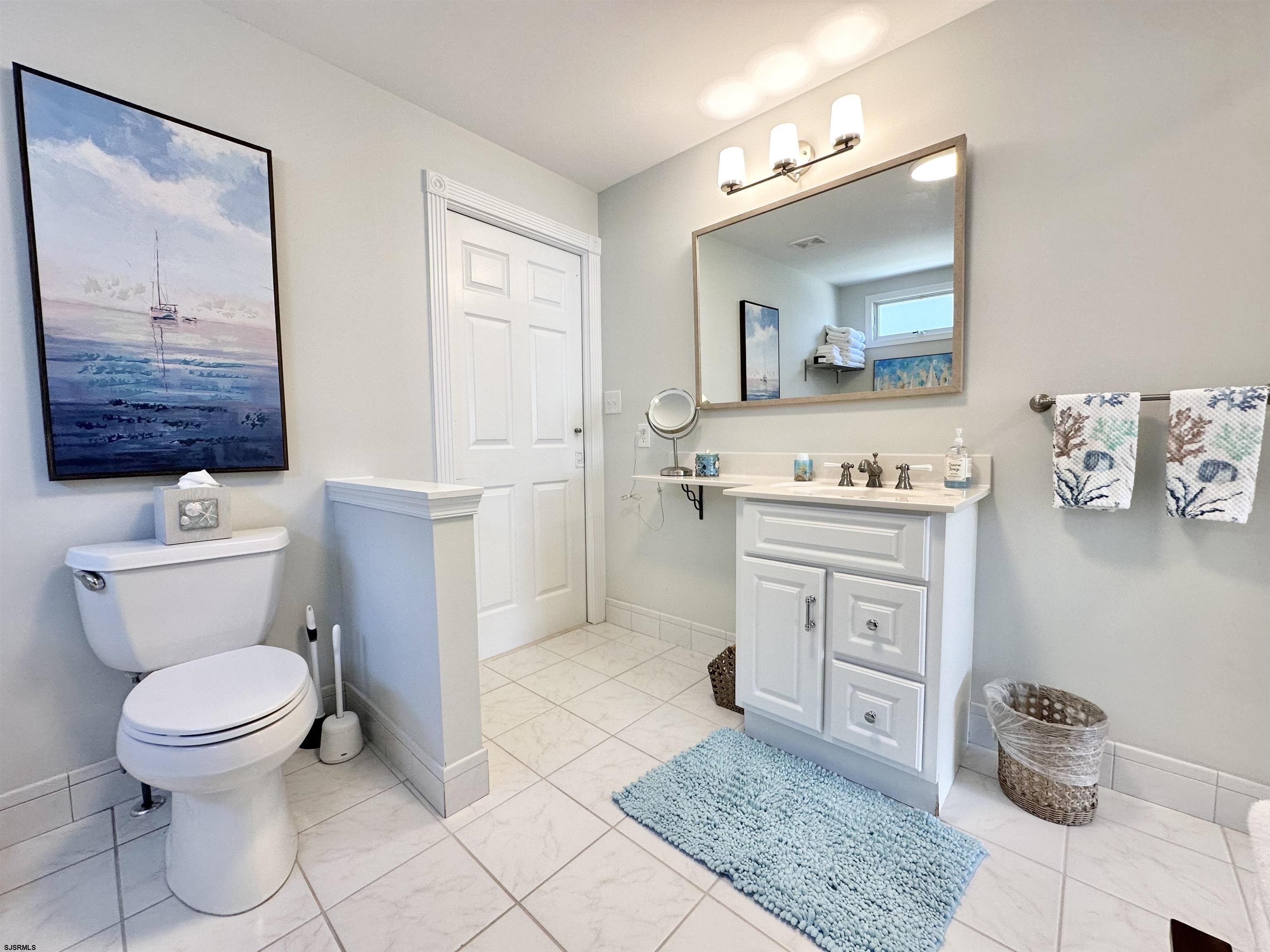 337 12th Street South Brigantine, NJ 08203 - Photo 11 of 36 a bathroom with a toilet a sink and mirror