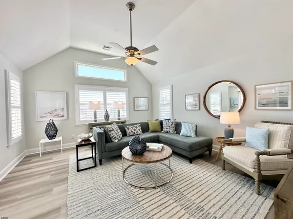 a living room with furniture a flat screen tv and a large window