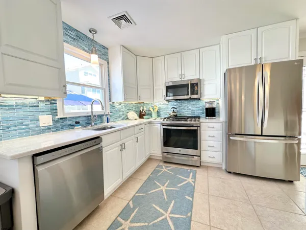 a kitchen with cabinets stainless steel appliances and window