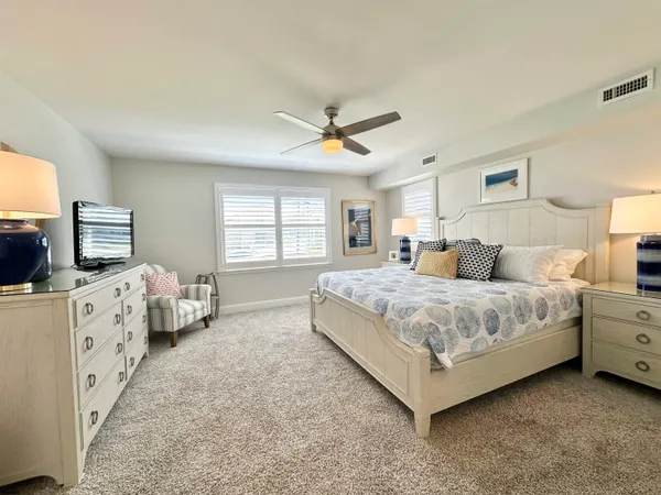 a spacious bedroom with a bed and a flat screen tv