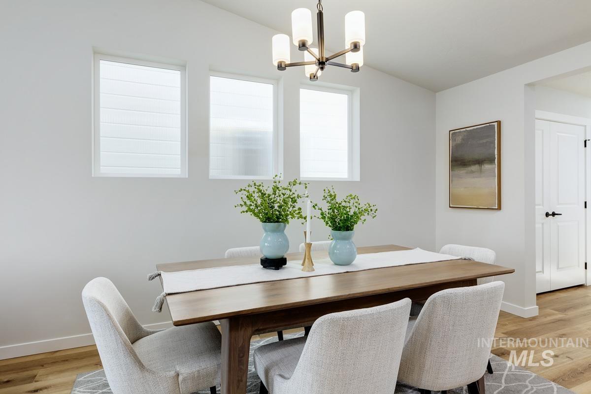 4309 South Zocalo Way Meridian, ID 83642 - Photo 5 of 26 Dining area featuring light wood-style flooring and a chandelier