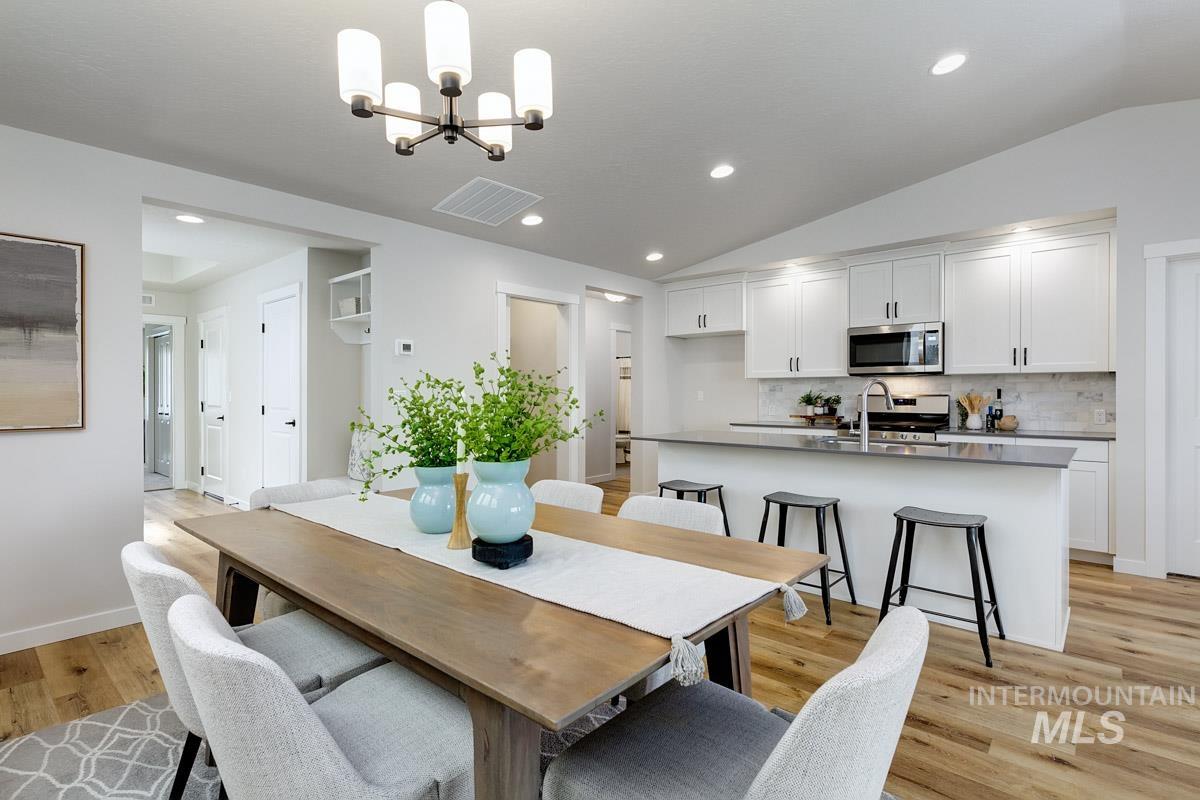 4309 South Zocalo Way Meridian, ID 83642 - Photo 6 of 26 Dining area featuring light wood finished floors, lofted ceiling, a chandelier, and recessed lighting
