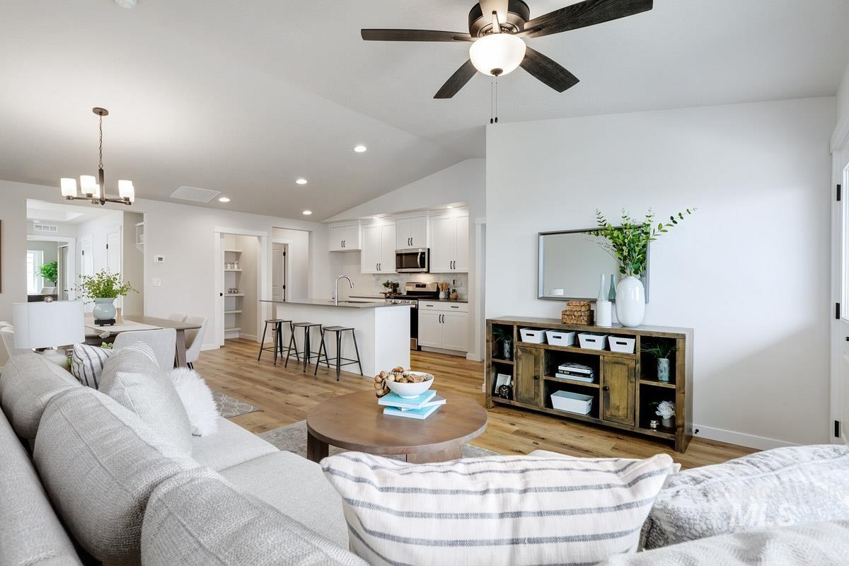 4309 South Zocalo Way Meridian, ID 83642 - Photo 9 of 26 Living area with vaulted ceiling, light wood-style floors, recessed lighting, a chandelier, and a ceiling fan