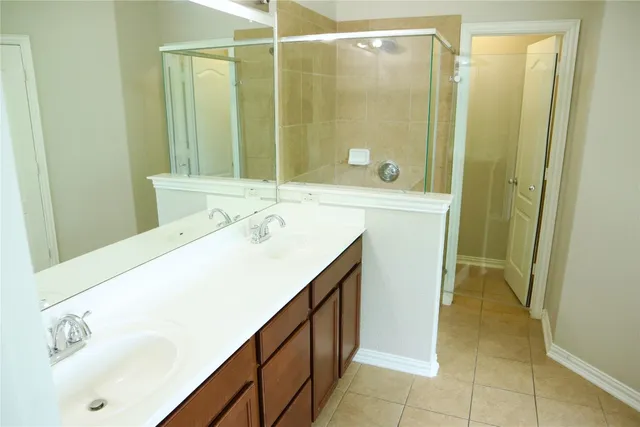 a spacious bathroom with a shower sink and mirror