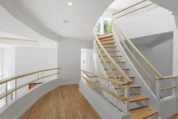 a view of staircase with railing and white walls