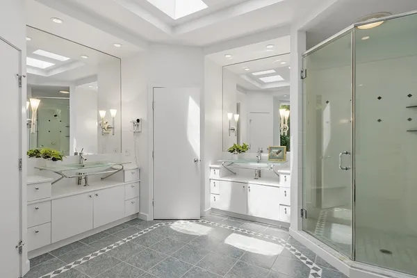 a bathroom with a double vanity sink mirror and shower