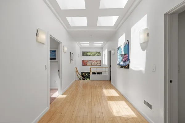 a view of a big room with wooden floor and windows