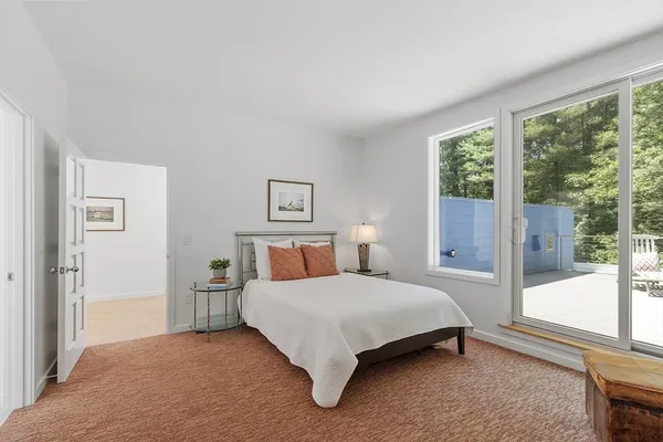 a bedroom with a bed lamp and a large window