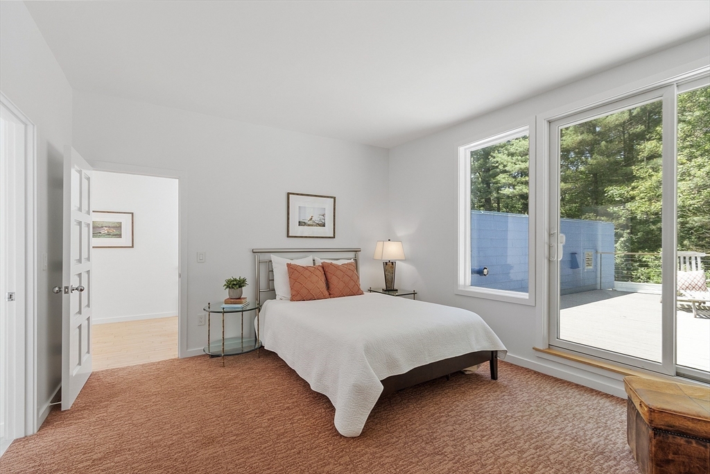 389 River Road Carlisle, MA 01741 - Photo 36 of 42 a bedroom with a bed lamp and a large window