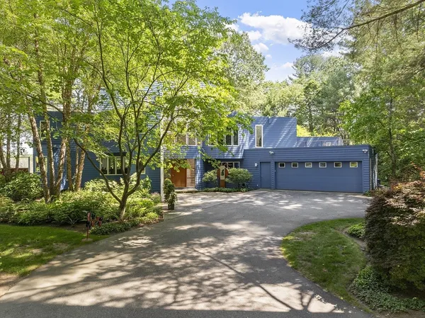 a view of a house with a yard and large trees