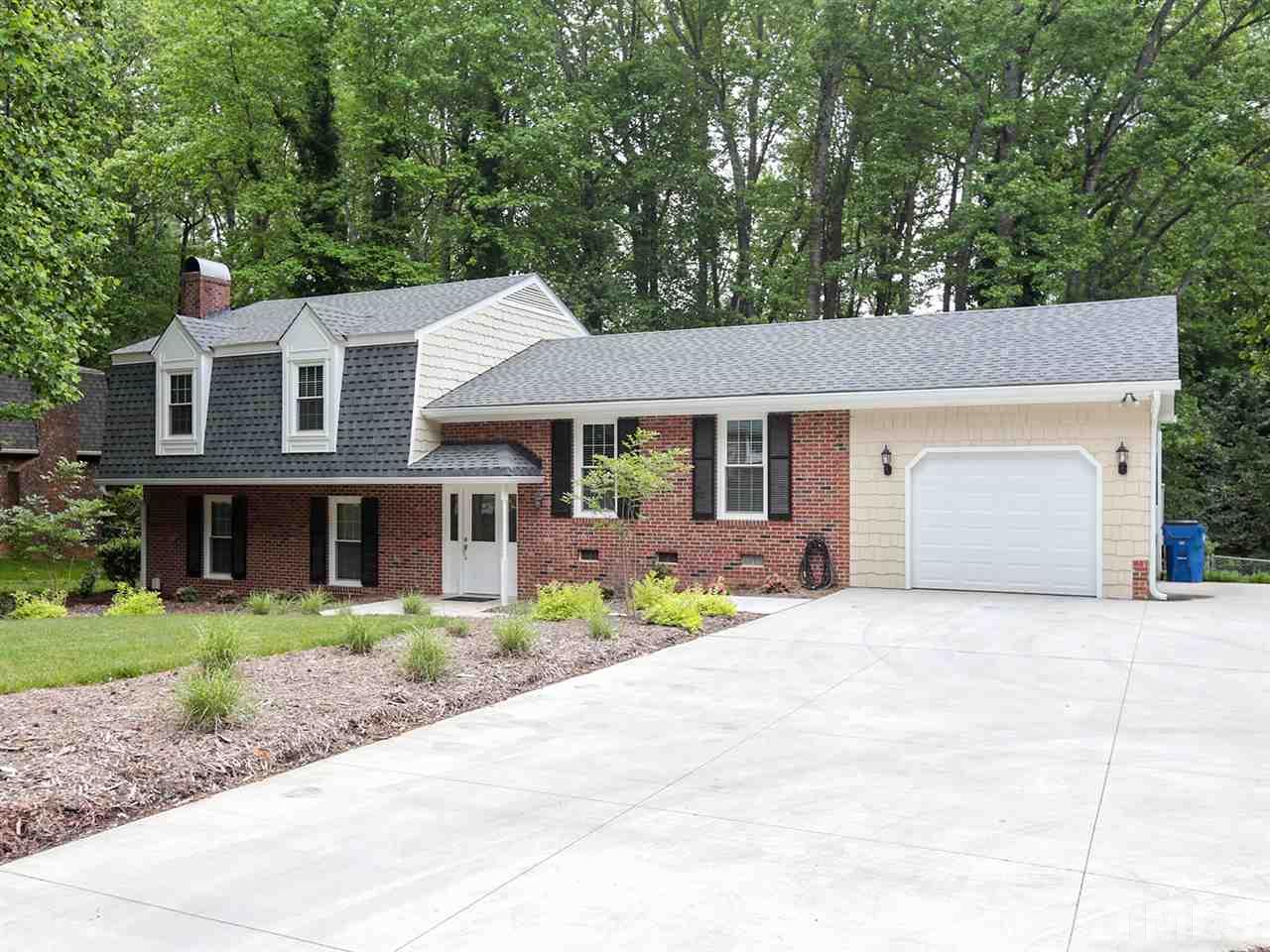 7316 Harps Mill Road Raleigh, NC 27615 - Photo 2 of 25 a front view of a house with a garden and trees