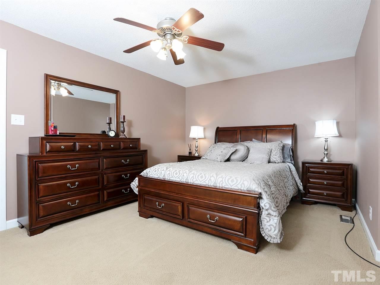 7316 Harps Mill Road Raleigh, NC 27615 - Photo 12 of 25 a bedroom with a bed and a chandelier