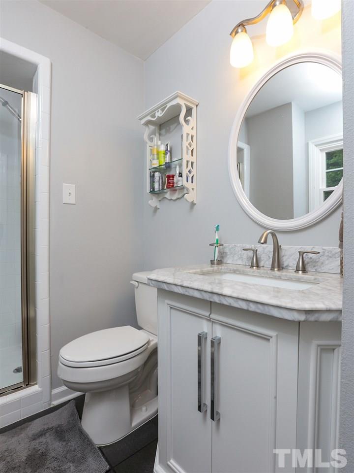 7316 Harps Mill Road Raleigh, NC 27615 - Photo 13 of 25 a bathroom with a granite countertop toilet sink and mirror