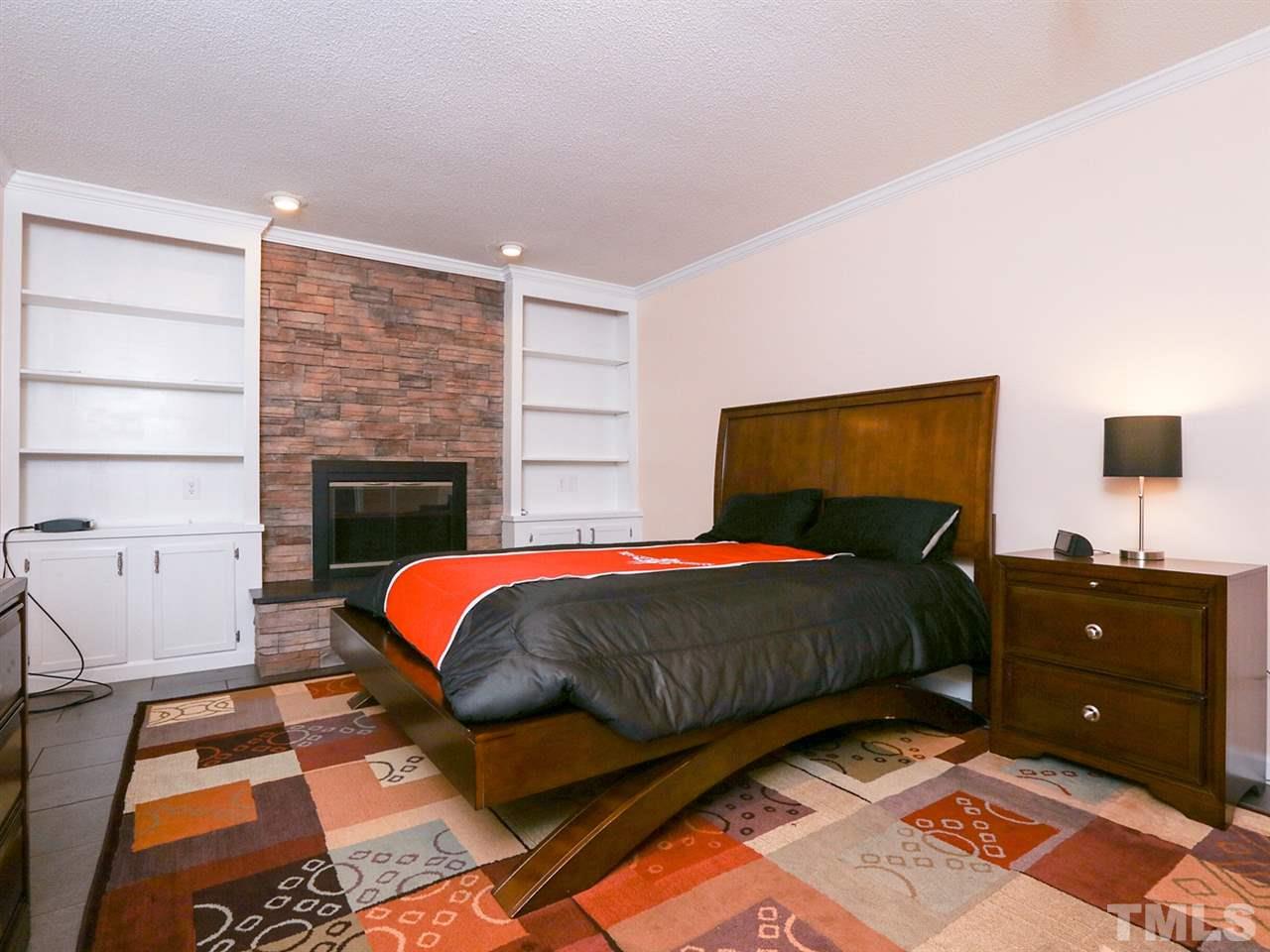 7316 Harps Mill Road Raleigh, NC 27615 - Photo 17 of 25 a bedroom with a bed and a fireplace