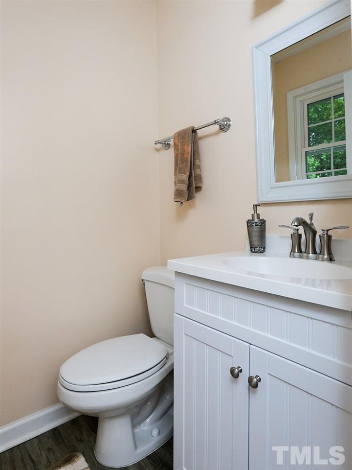 7316 Harps Mill Road Raleigh, NC 27615 - Photo 19 of 25 a bathroom with a toilet a sink and mirror