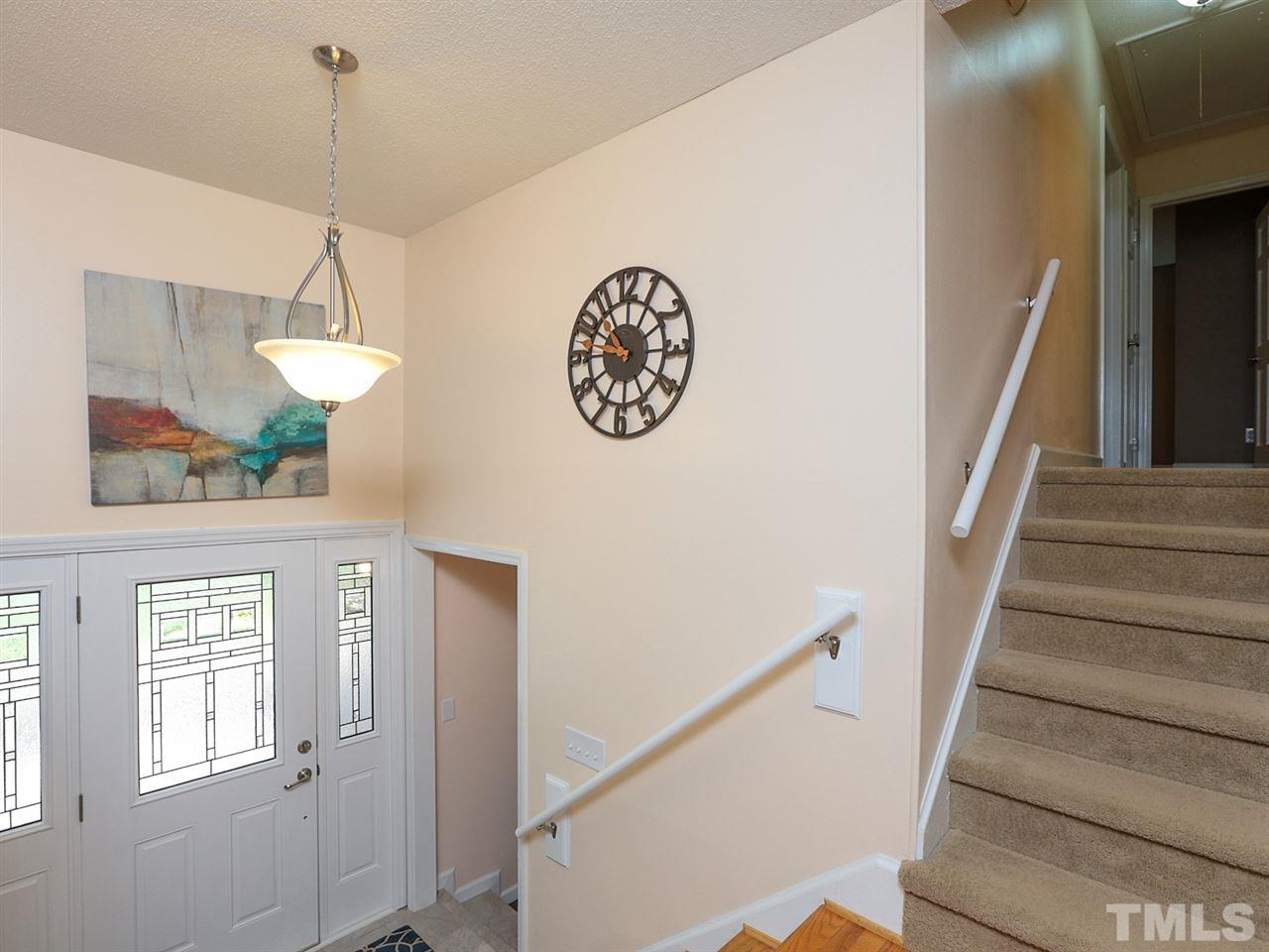 7316 Harps Mill Road Raleigh, NC 27615 - Photo 3 of 25 a view of a hallway with windows and chandelier